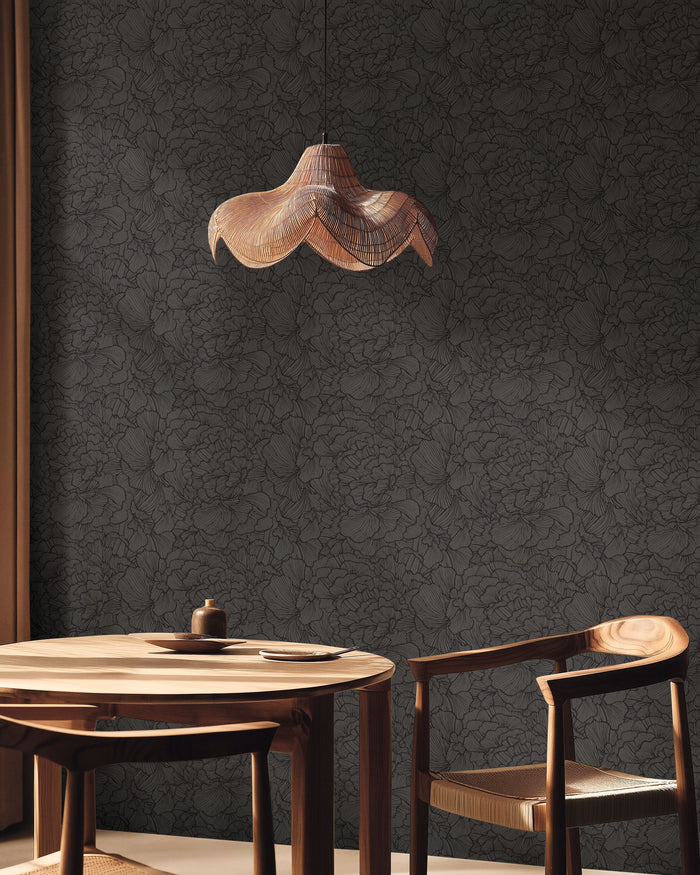 Delicate Petals in Noir from Moonlight 3 by Caselio, a near black petal print in a dining room with a sculptural pendant and a round wooden table