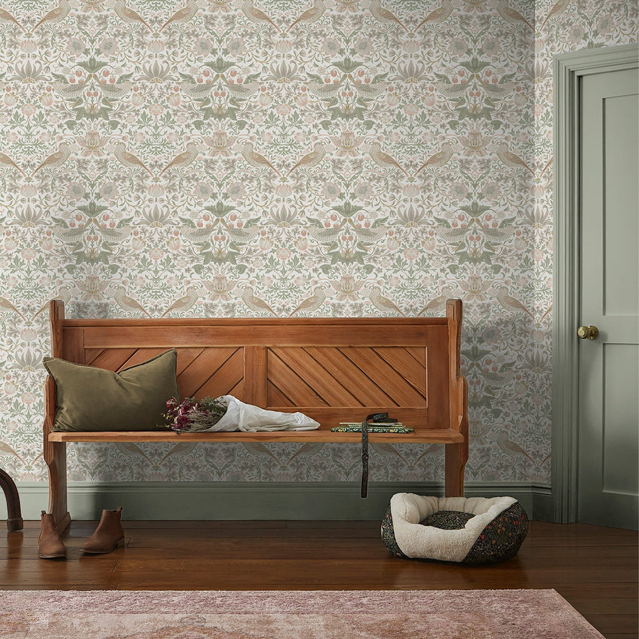 William Morris wallpaper in a classic Arts and Crafts botanical pattern, the Strawberry Thief design in pale sage in a hallway with a wooden bench