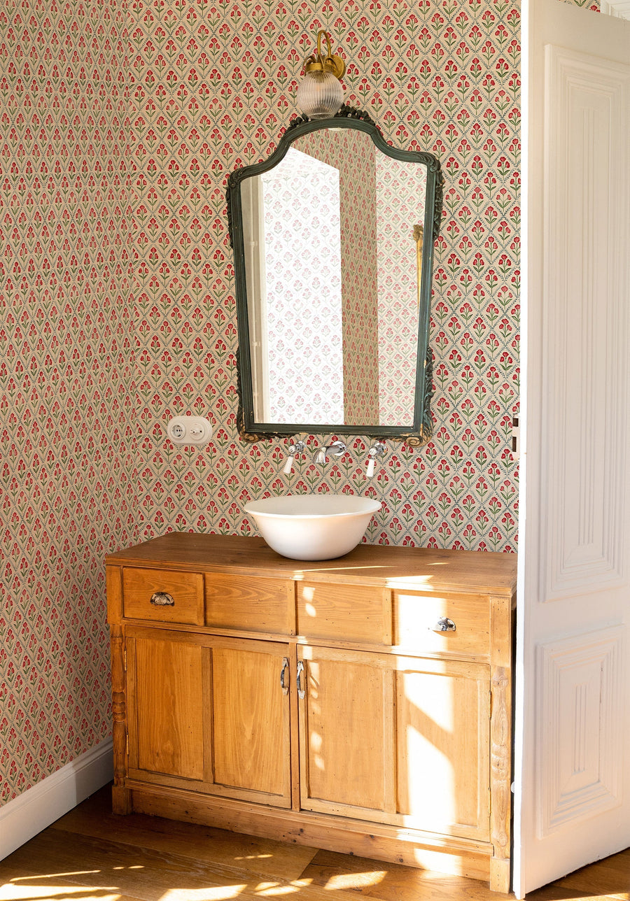 Poppy Red wallpaper by Coordonne, a fine Victorian poppy print in warm red above a wooden vanity and a shaped mirror