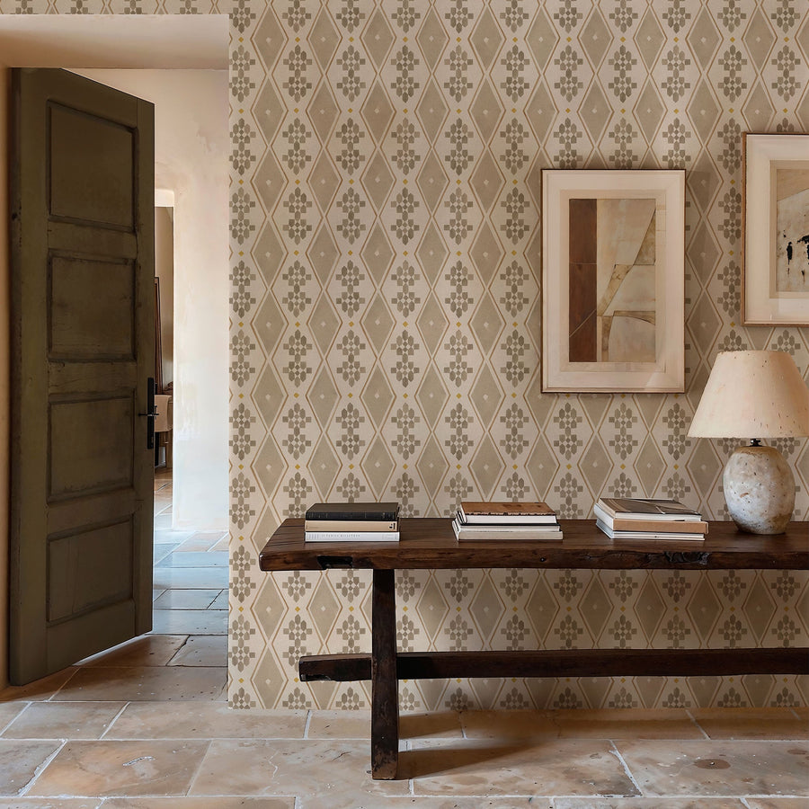 Beldi Rugs Bone wallpaper by Coordonne, a bone and taupe berber diamond motif in a hallway with a dark green door, a long dark wood bench and a terracotta tiled floor