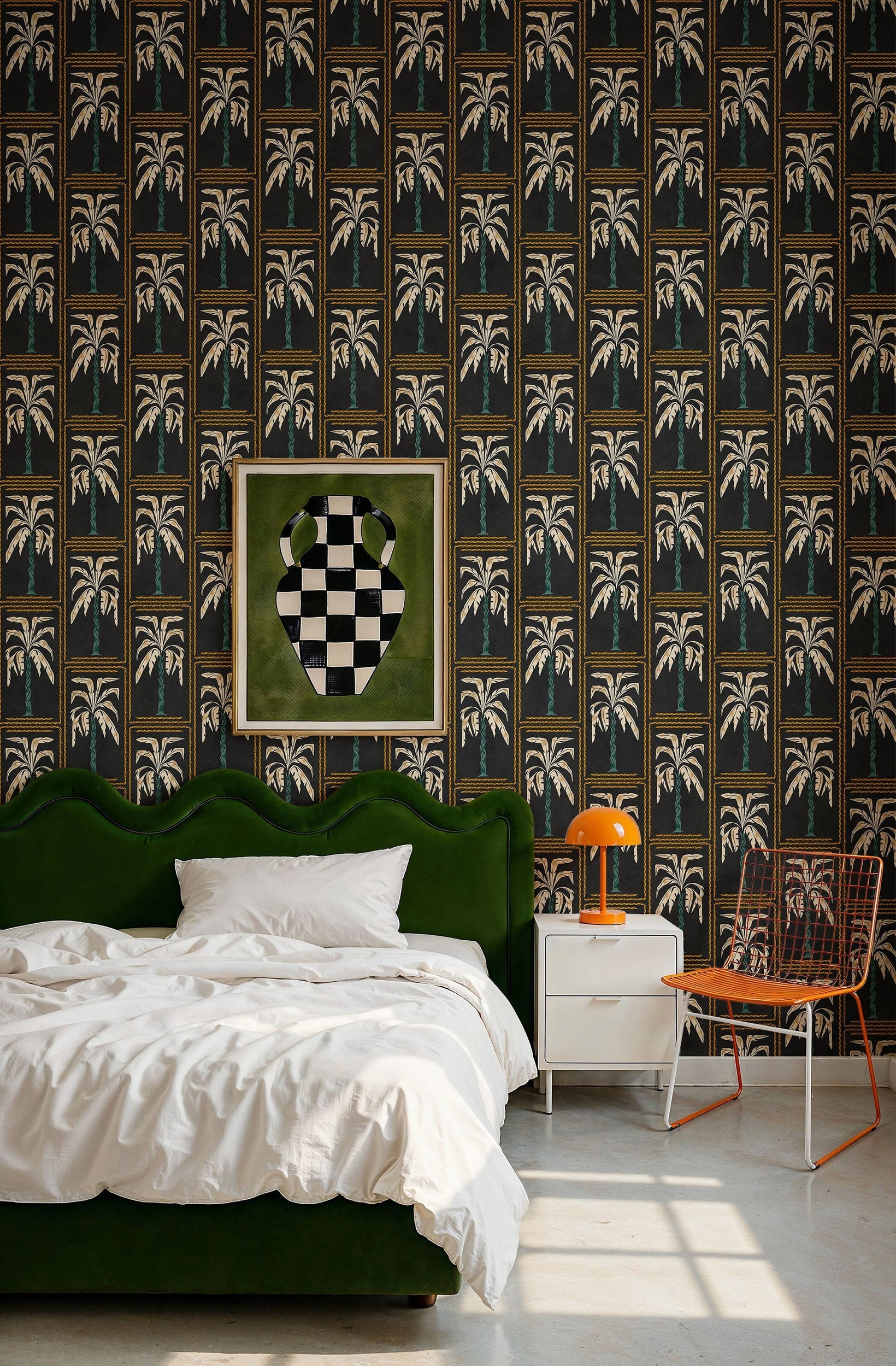 Veraneo Noir wallpaper by Coordonne, gold palm columns on black behind a green velvet bed and an orange lamp