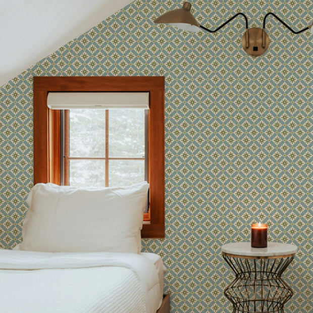 Nova and Sol wallpaper by Josephine Munsey, a small hand painted celestial print papered across the sloping walls of an attic bedroom