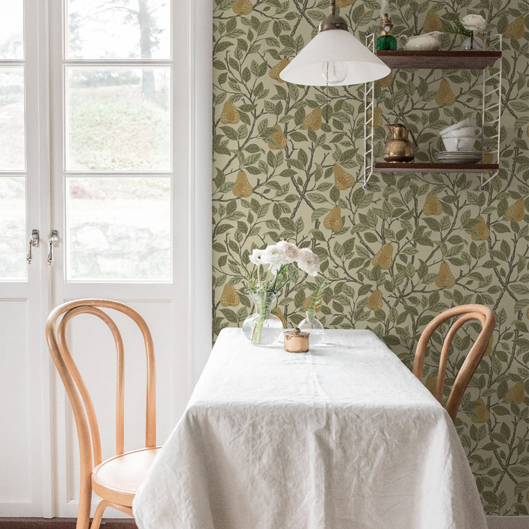 Pirum Beige wallpaper by Galerie, ripe pears among leaves on olive, behind a laid breakfast table with bentwood chairs